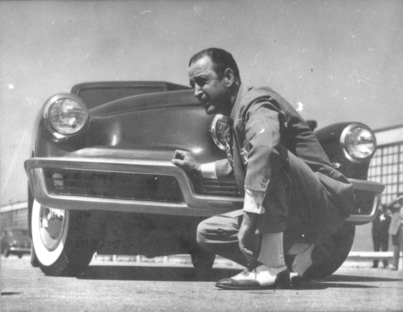 Preston Tucker crouching beside a Tucker